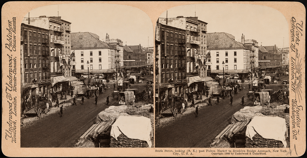 Sepia stereoscopic photo of a busy city street with horse-drawn carts, vendors, and pedestrians near market buildings, likely in Brooklyn, New York, circa early 1900s. Signs and shopfronts line the street.