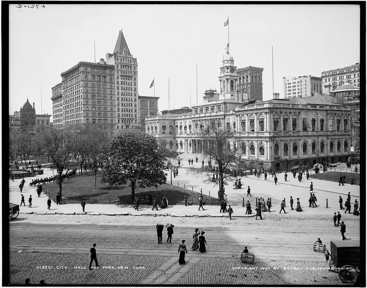 Black and white photo of New York City Hall and its surrounding park in the early 1900s, with people walking, trees, and several tall buildings in the background.