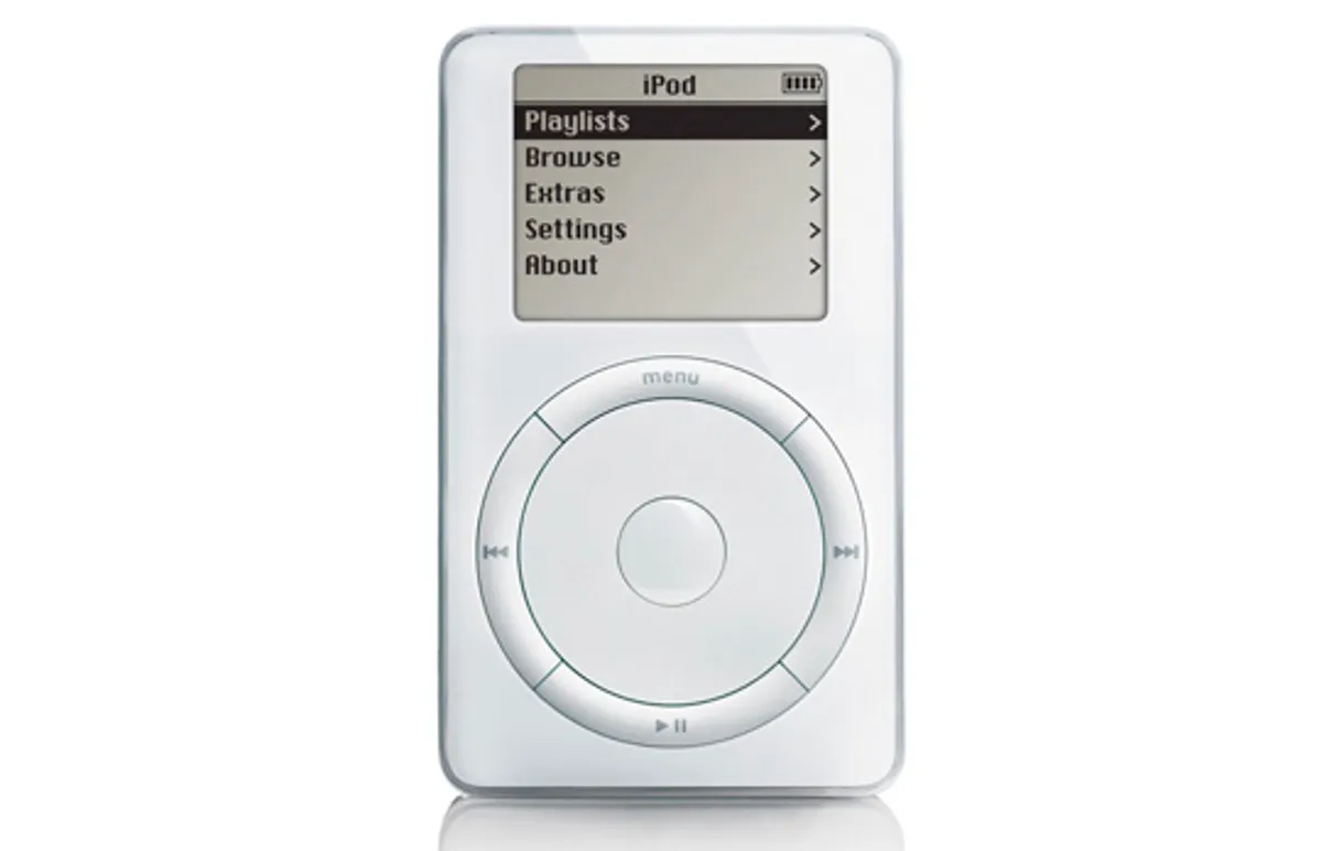 A classic first-generation Apple iPod with a monochrome screen displaying a menu and a circular scroll wheel with buttons below the screen. The device is white and rectangular. Gadget.