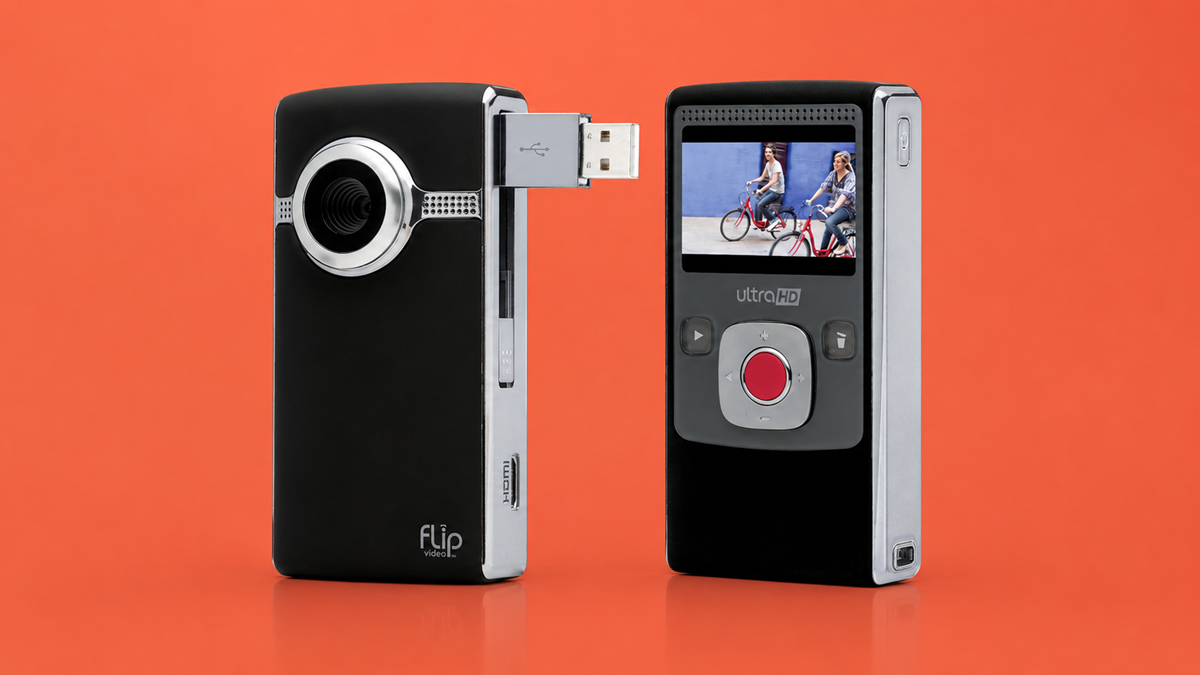 Two Flip Video camcorders are shown against an orange background; one displays the lens and a popped-out USB connector, while the other shows the screen, buttons, and a video of people riding bikes.