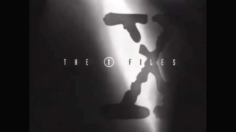 Black and white image of "The X-Files" TV show logo, with the words "THE X FILES" overlaid on a large shadowy letter X illuminated by a beam of light.
