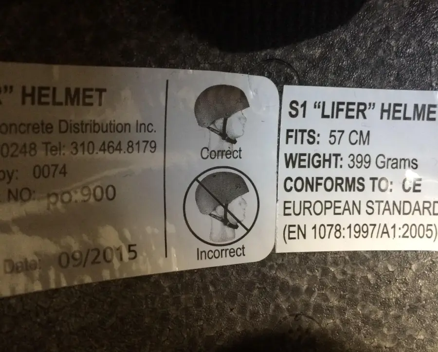 Helmet label showing two diagrams: one with a helmet worn correctly (labeled "Correct") and one with a helmet tipped back exposing the forehead (labeled "Incorrect"). Additional helmet details and specs are listed on the label.
