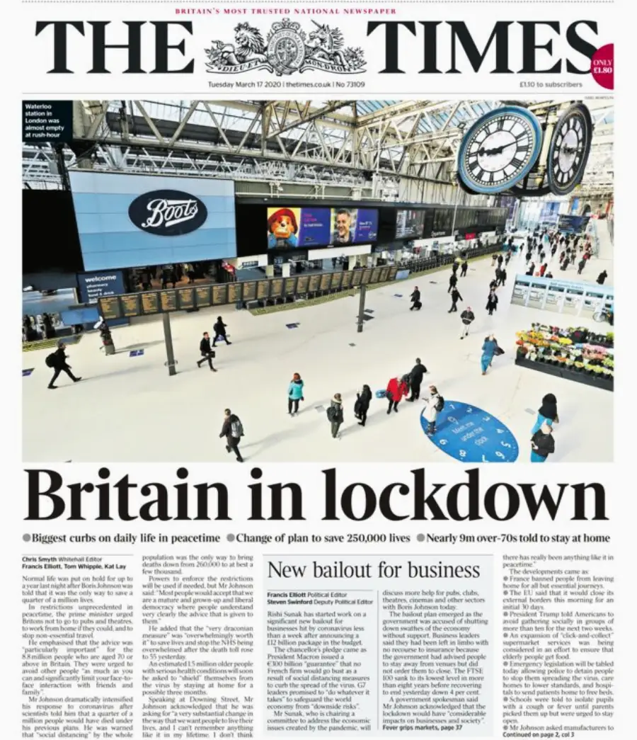 Front page of The Times newspaper shows a mostly empty train station with a few people walking. The headline reads “Britain in lockdown” and discusses restrictions and business aid during the COVID-19 pandemic.