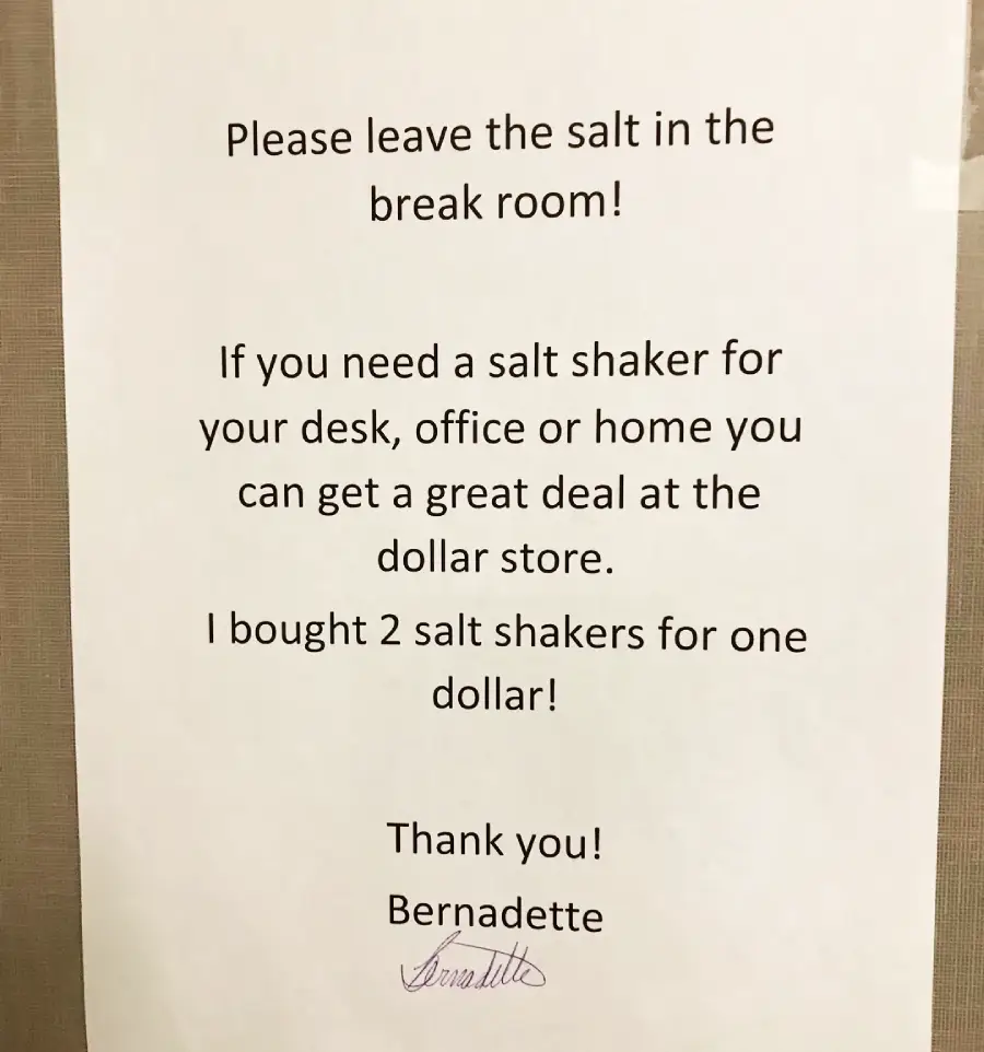 A printed sign asks people to leave the salt in the break room and suggests buying salt shakers at the dollar store, mentioning two shakers cost one dollar. It’s signed “Thank you! Bernadette.”
