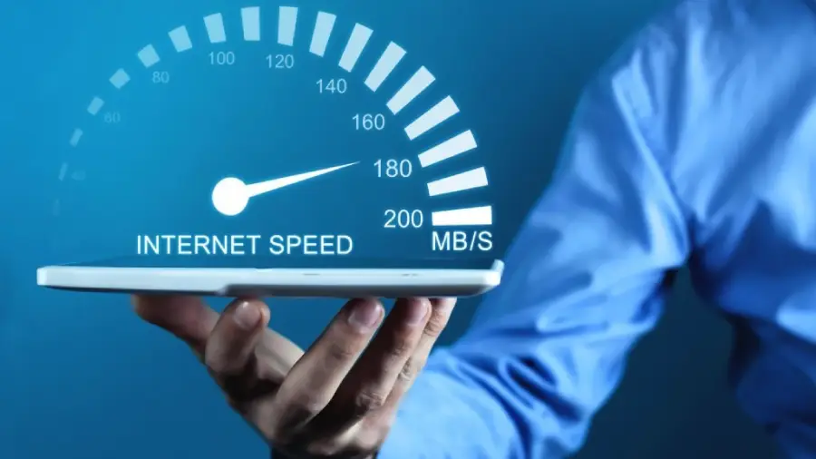 A person holds a tablet with an illustrated speedometer above it, labeled "Internet Speed" in MB/S, suggesting high or fast internet connectivity.
