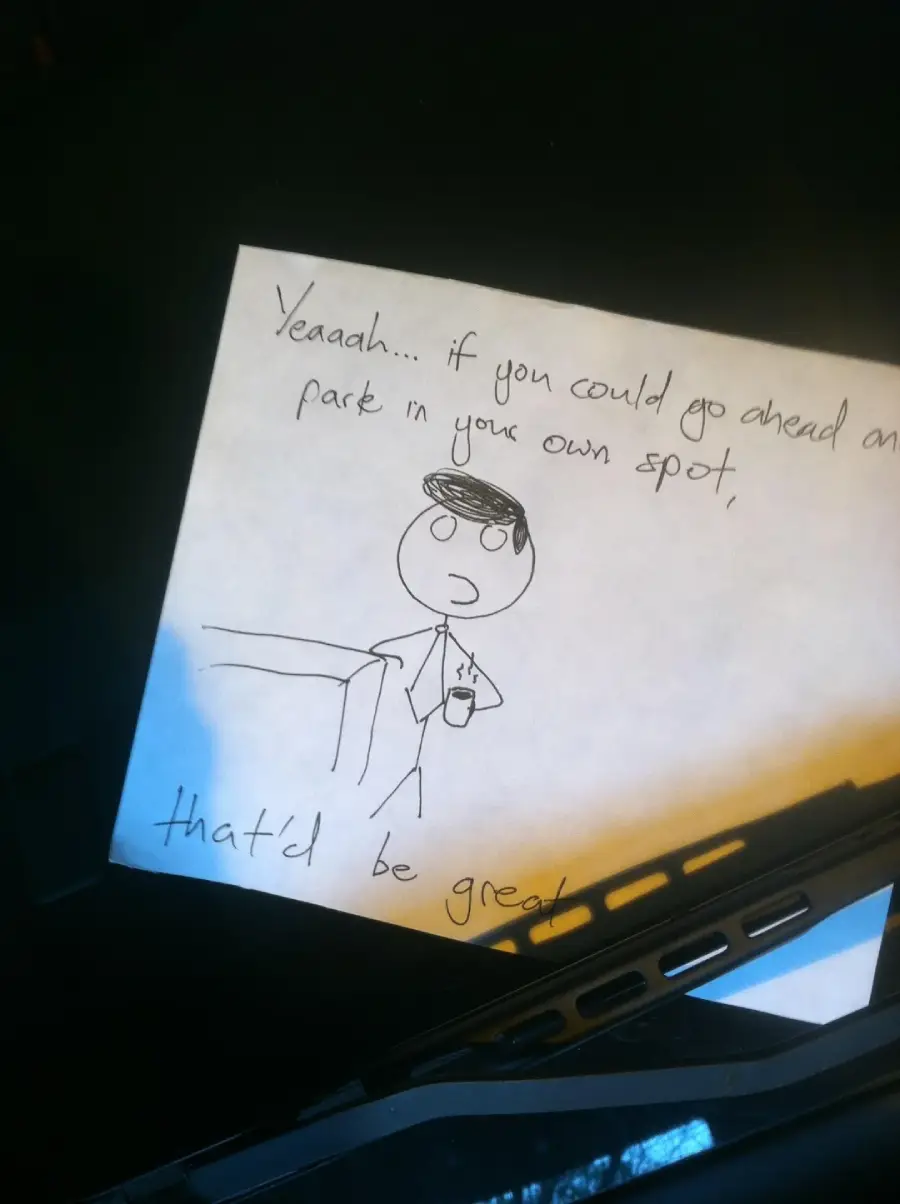 A handwritten note under a windshield wiper shows a stick figure in an office shirt and tie holding a coffee cup, with the text: "Yeaah... if you could go ahead and park in your own spot, that'd be great.