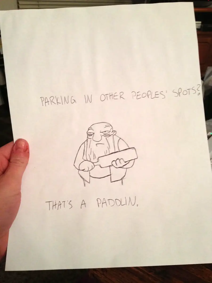 A hand holds a paper with a drawing of a stern, elderly person holding a paddle. The text reads, "PARKING IN OTHER PEOPLES' SPOTS? THAT'S A PADDLIN.