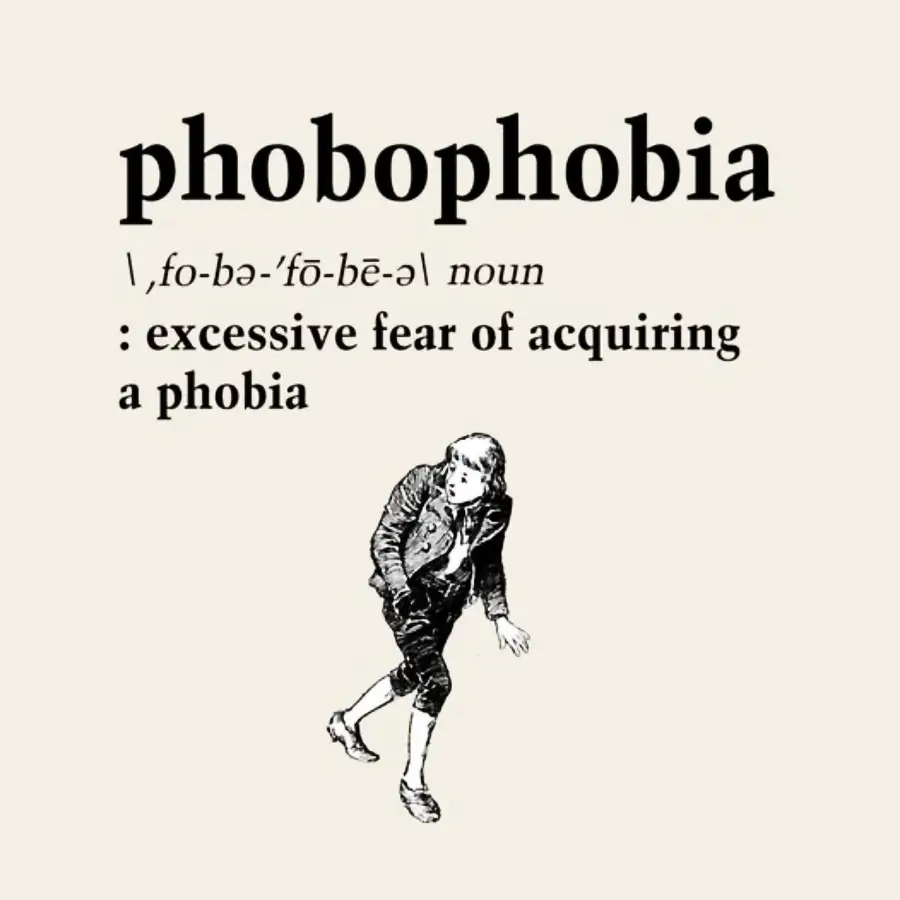The word "phobophobia" is defined as an excessive fear of acquiring a phobia. Below the definition, there is a black-and-white illustration of a nervous-looking person cowering and glancing backward.