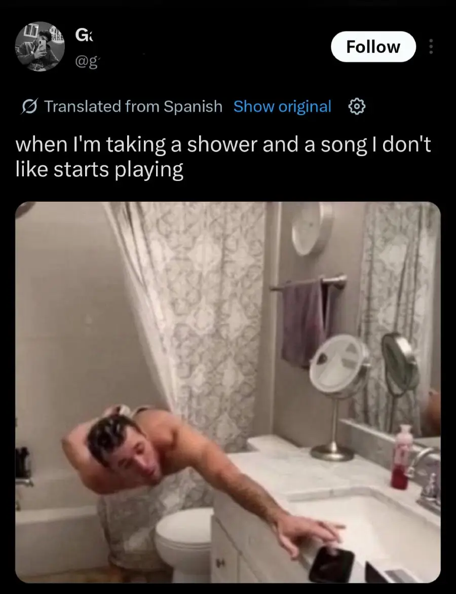 A man is leaning out of the shower, dripping wet, reaching toward a phone on the bathroom counter. The caption reads, "when I'm taking a shower and a song I don't like starts playing.