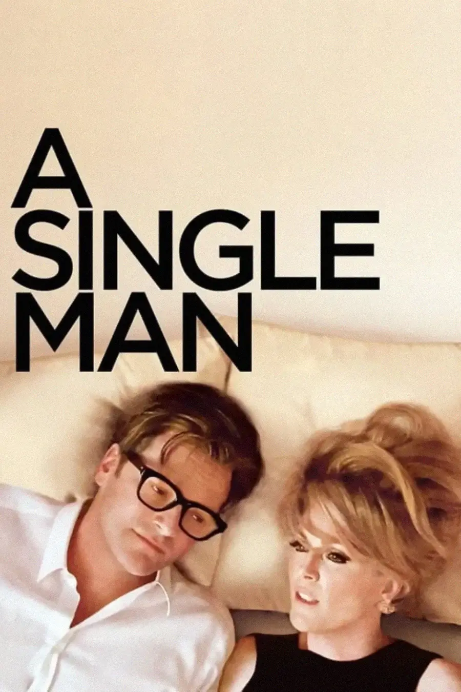 A man with glasses and a woman with blonde hair lie side by side on a bed, looking thoughtful. Large black text above them reads "A SINGLE MAN" against a plain light background.