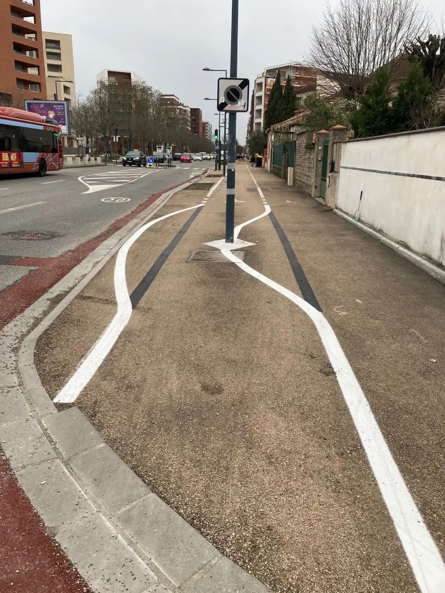 A sidewalk with white lines painted in a wavy, erratic manner to avoid a streetlamp placed in the middle of the path, making the lines look unconventional and humorous.