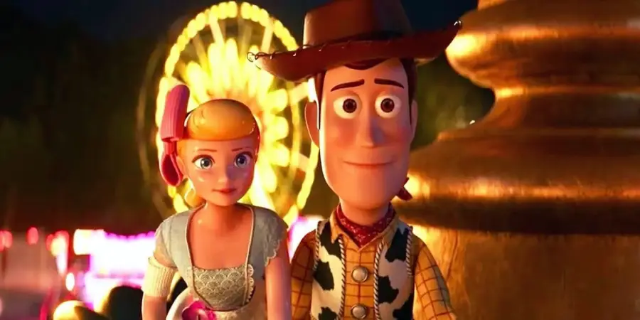 Woody and Bo Peep, animated toy characters from Toy Story, stand close together and smile with a brightly lit Ferris wheel in the background at night.