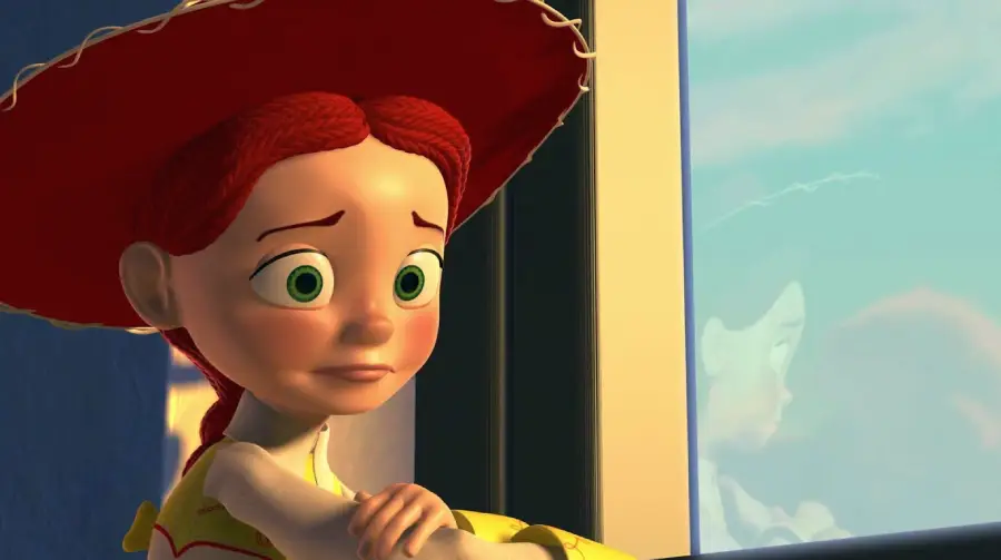 An animated character with red braided hair and a large red hat looks sad while gazing out a window, her reflection visible in the glass.