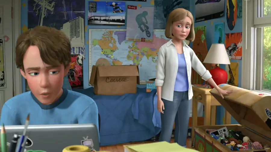 A teenage boy sits at a desk looking at his laptop, while a woman stands nearby, touching a toy chest. The room is filled with posters, toys, and a "College" box, suggesting he is preparing to leave for college.