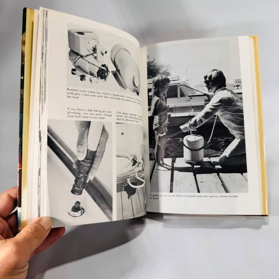 A hand holds open a book showing black-and-white photos of boating equipment and people on a dock. Technical diagrams and text instructions are visible on the left page.