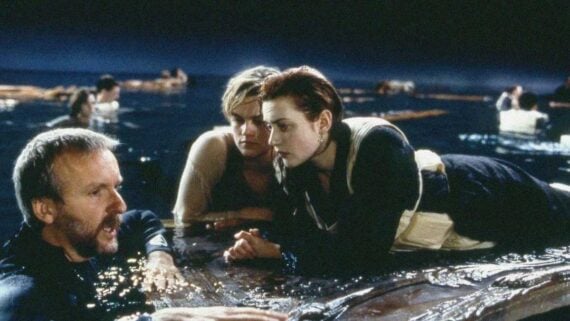 Director James Cameron giving instructions to Leonardo DiCaprio and Kate Winslet while filming a water scene for Titanic.