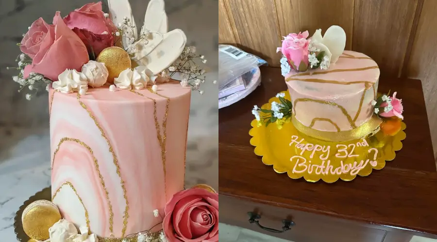 Two pink and white marbled cakes with gold accents, fresh roses, and white chocolate decorations; the right cake says “Happy 32nd Birthday” in yellow icing on a gold tray.