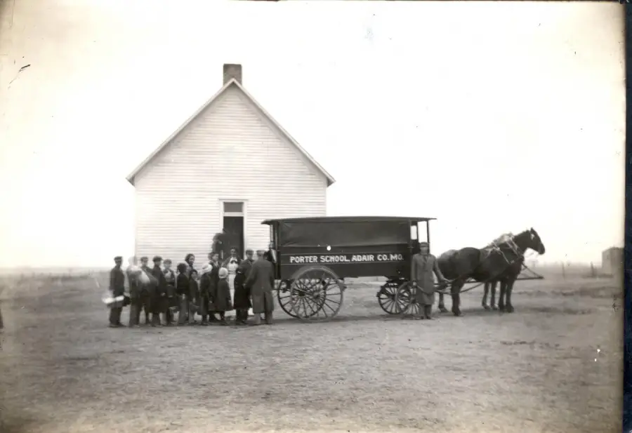 A black-and-white photo shows children and adults standing by a horse-drawn school wagon labeled "Porter School, Adair Co. Mo." in front of a white, one-room schoolhouse.