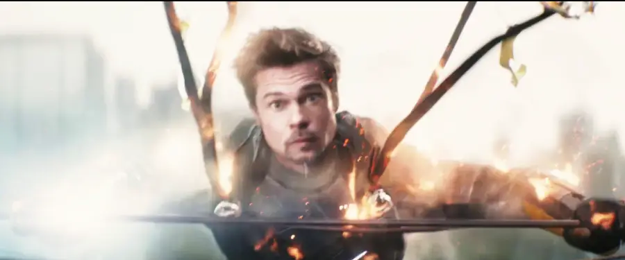 A man in a superhero suit is suspended in midair with metal rods and sparks flying around him, as if caught in an explosion or intense action scene.