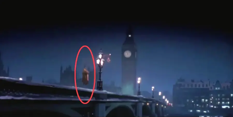 A person is floating above a bridge near Big Ben at night, illuminated by street lamps. The scene is dark and misty, with the person circled in red for emphasis.