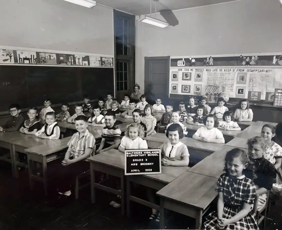 Black and white photo of a classroom with young children seated at desks. A sign in front reads "Allendale Highlands Elementary School, Grade 3, Mrs. Brookby, April 1958." Drawings are displayed on the walls.