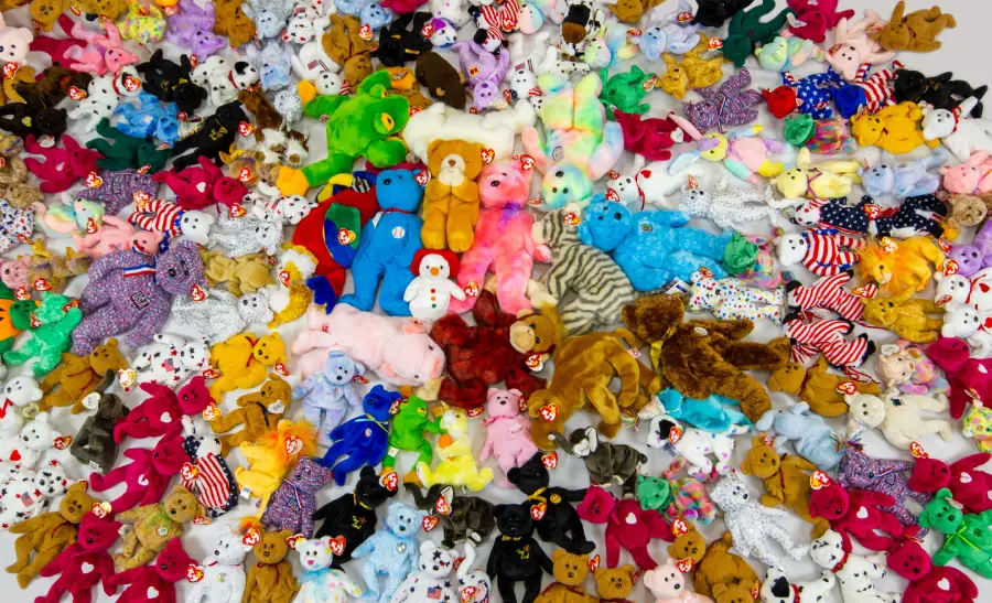 A large collection of colorful Beanie Babies plush toys arranged closely together, creating a vibrant and crowded display with various animals and patterns.