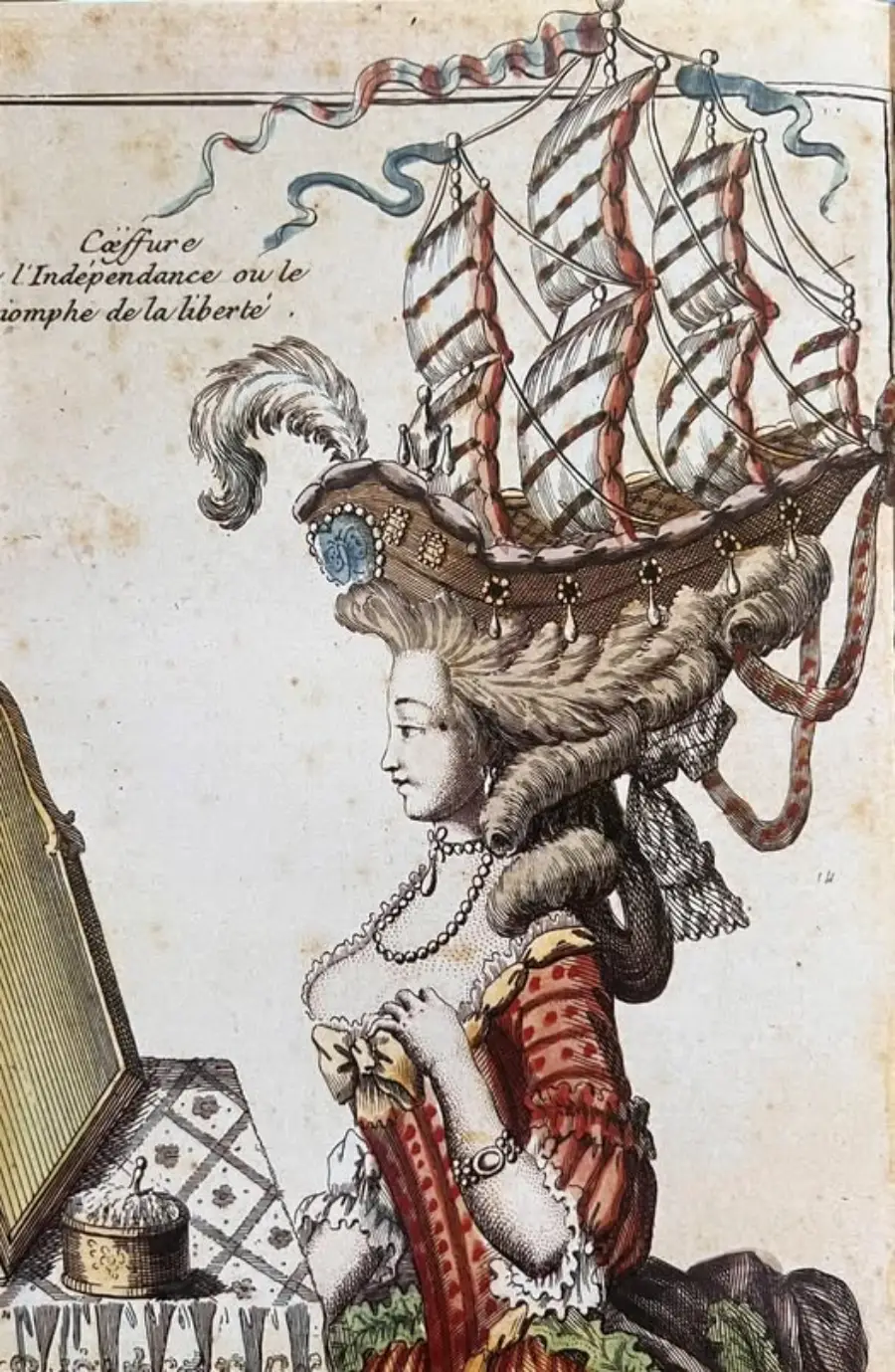 An 18th-century woman sits at a vanity, wearing an elaborate hairstyle shaped like a sailing ship with flags and feathers. The illustration is ornate and detailed, with period clothing and accessories.