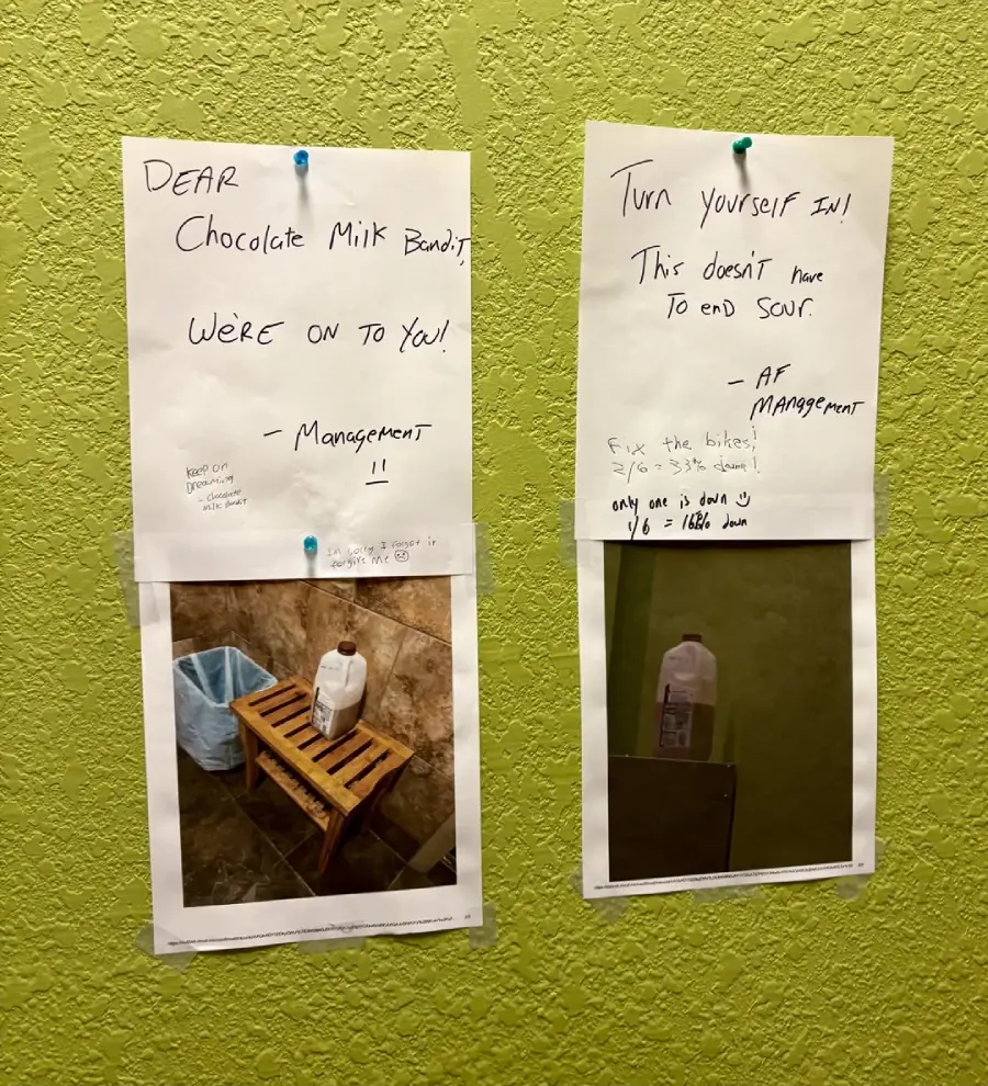 Two notes and two photos are pinned to a green wall. The notes mention a "Chocolate Milk Bandit" and ask them to turn themselves in. The photos show a discarded milk bottle near a wooden bench.