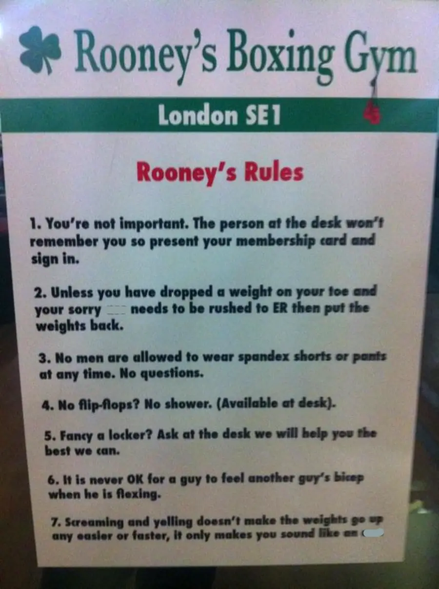 A sign titled "Rooney's Boxing Gym" lists humorous gym rules, including membership card use, not dropping weights on toes, no spandex shorts, shower rules, locker availability, flexing biceps, and yelling etiquette.