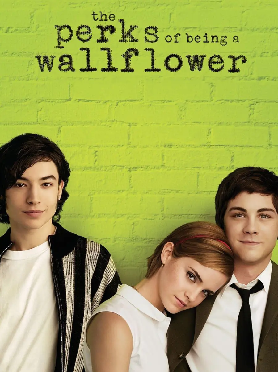 Three young people stand against a green brick wall. "The Perks of Being a Wallflower" is written above them in black text. The central figure leans their head on one person's shoulder.