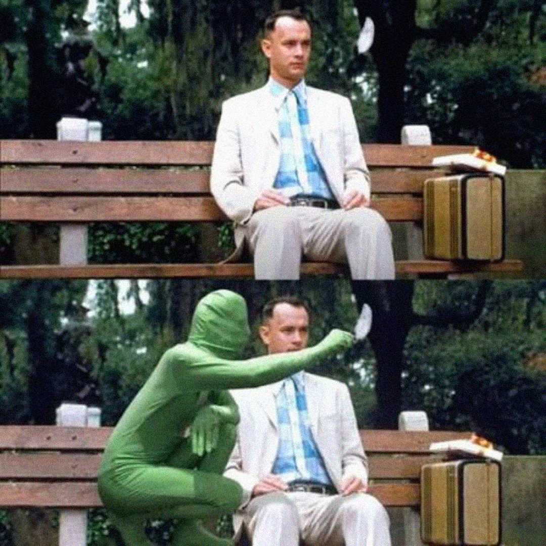 Two-panel image: In both panels, a man in a suit sits on a park bench with a suitcase. In the second panel, a person in a green full-body suit appears, holding a feather near the man's face.
