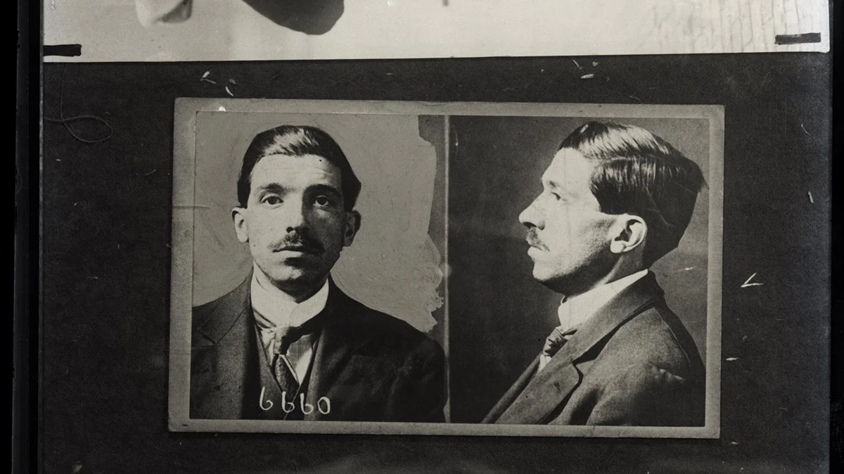 Black and white mugshot shows a man with a mustache in a suit, facing both forward and to the side. The numbers 6660 are visible below the front-facing image. scam