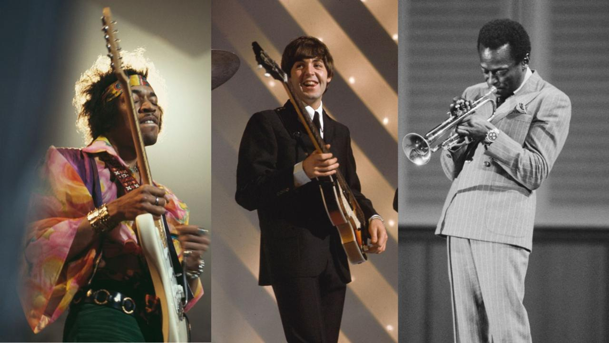 Three musicians on stage: left, a person in colorful clothing playing electric guitar; center, a person in a suit playing guitar and smiling; right, a person in a light suit playing trumpet.