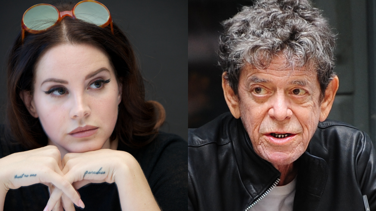 A woman with long brown hair, wearing sunglasses on her head, rests her chin on her hands. Beside her, an older man with gray curly hair wears a black jacket and looks slightly to the side.