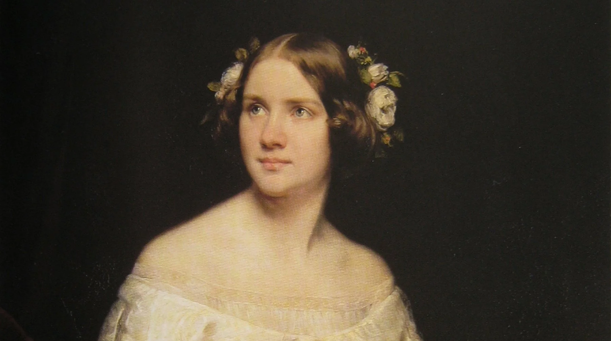 A woman with brown hair styled in ringlets adorned with white flowers, wearing an off-the-shoulder white dress, poses against a dark background in a classical portrait style.