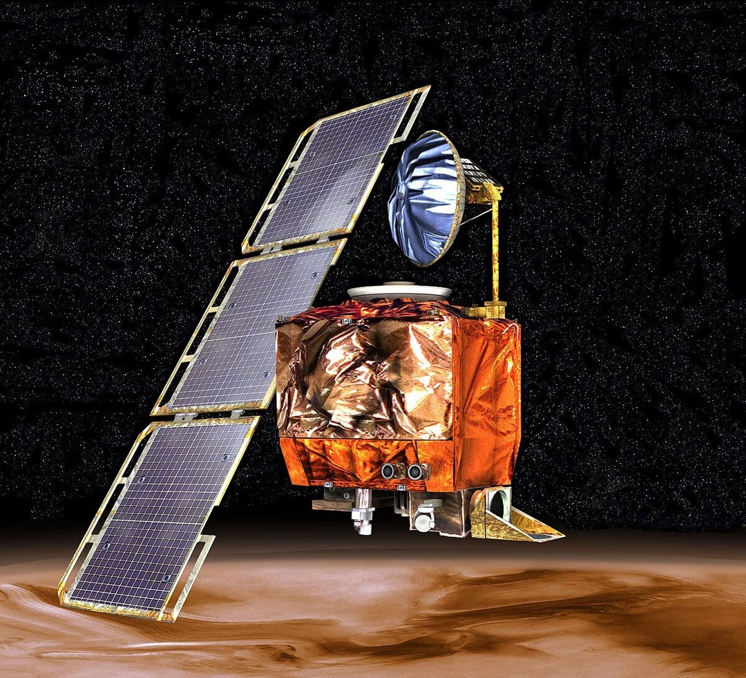 A satellite with large solar panels and metallic body orbits over a reddish-brown planet against a starry space background.