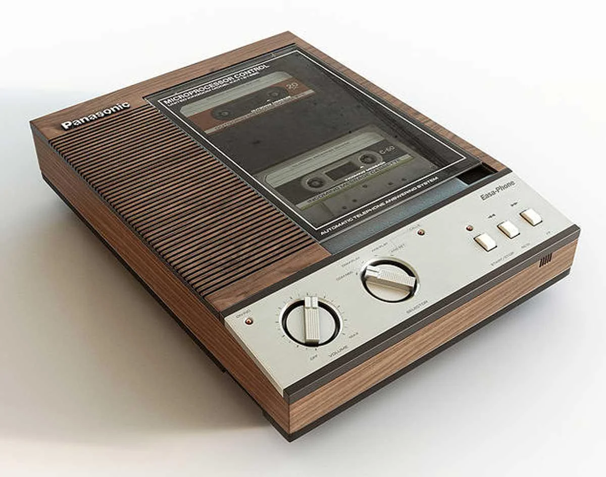 A vintage Panasonic cassette tape recorder with wood paneling, dials, and buttons on the front, and an inserted cassette tape visible through a transparent cover.