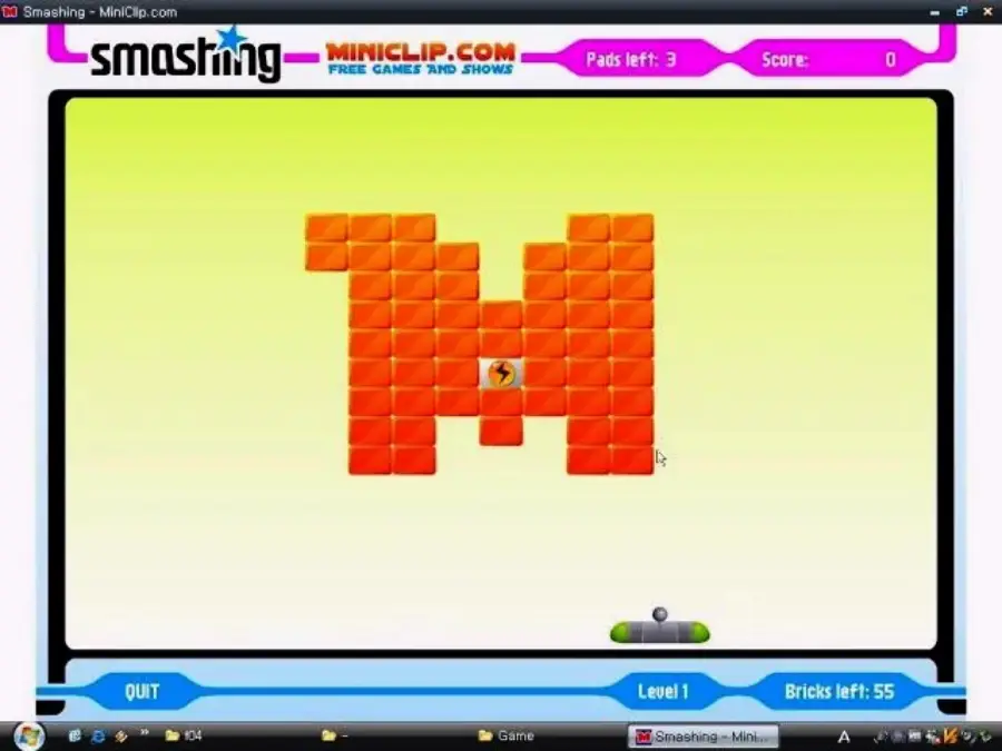 Screenshot of a Miniclip browser game called "Smashing," showing an orange "M" made of bricks. A ball bounces above a paddle at the bottom, with score and bricks left displayed at the top.