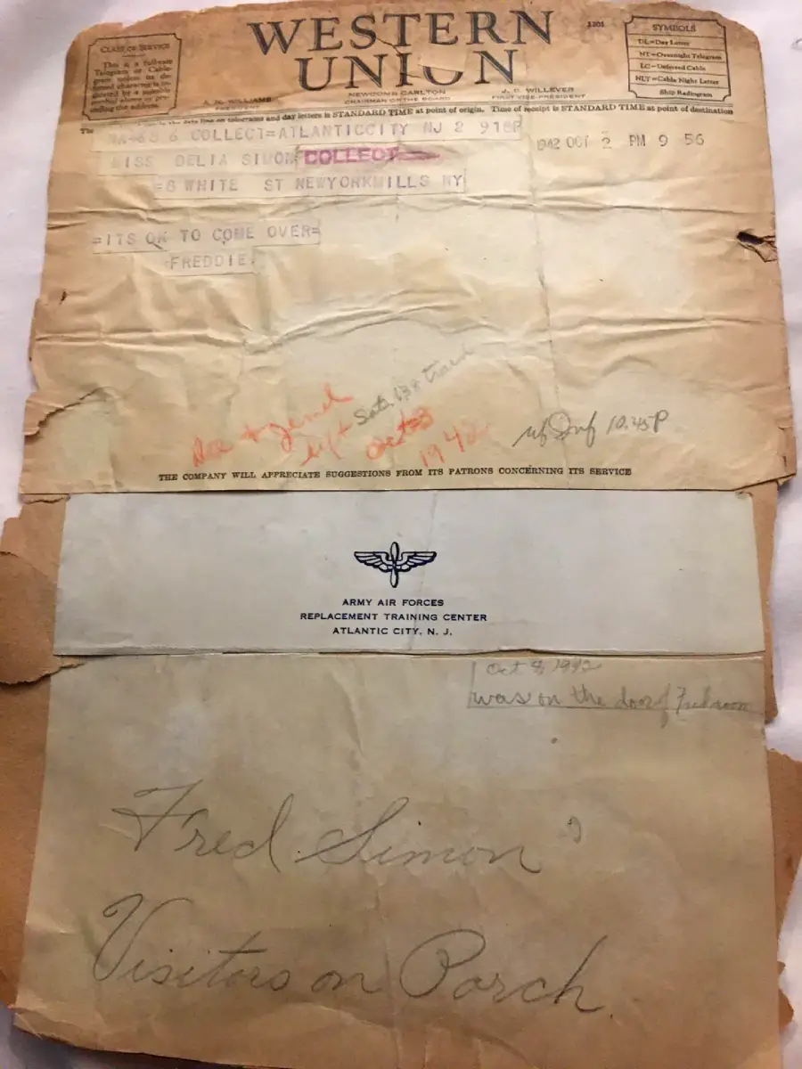 A worn Western Union telegram from 1945 is shown above a brown Army Air Force envelope labeled “Fred Simon Visits on Porch,” with handwritten notes and faded, aged paper.