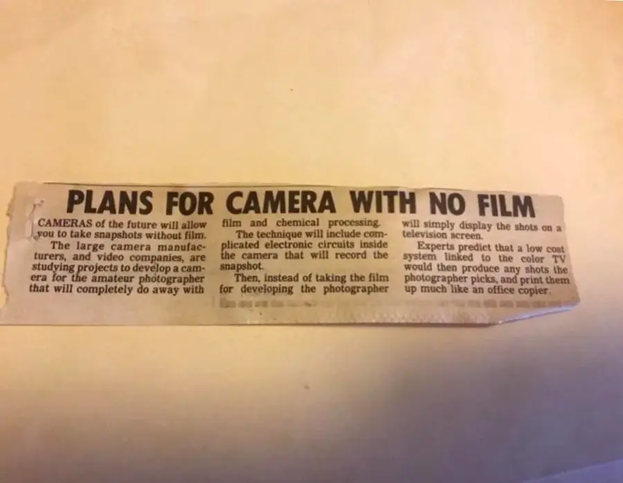A newspaper clipping titled "Plans for camera with no film" discusses future cameras that take snapshots without film, using electronic circuits to display images on a TV screen instead of traditional film.