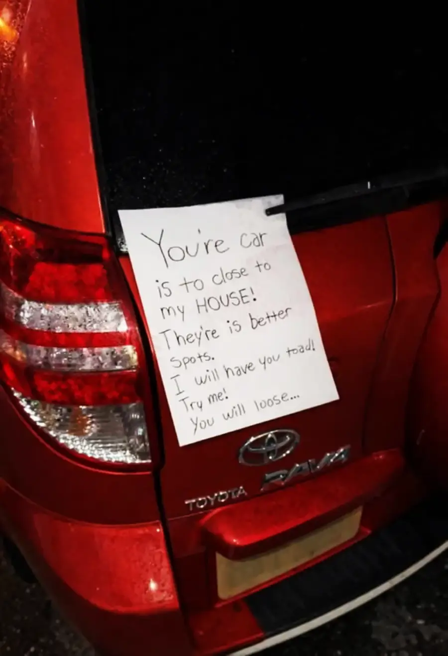 A handwritten note on a red Toyota RAV4 reads: "You're car is to close to my HOUSE! They're is better spots. I will have you toad! Try me! You will loose...