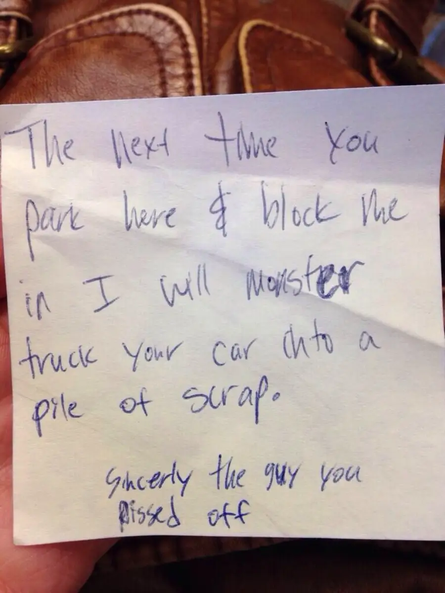 A handwritten note reads: “The next time you park here & block me in I will monster truck your car into a pile of scrap. Sincerely, the guy you pissed off.”