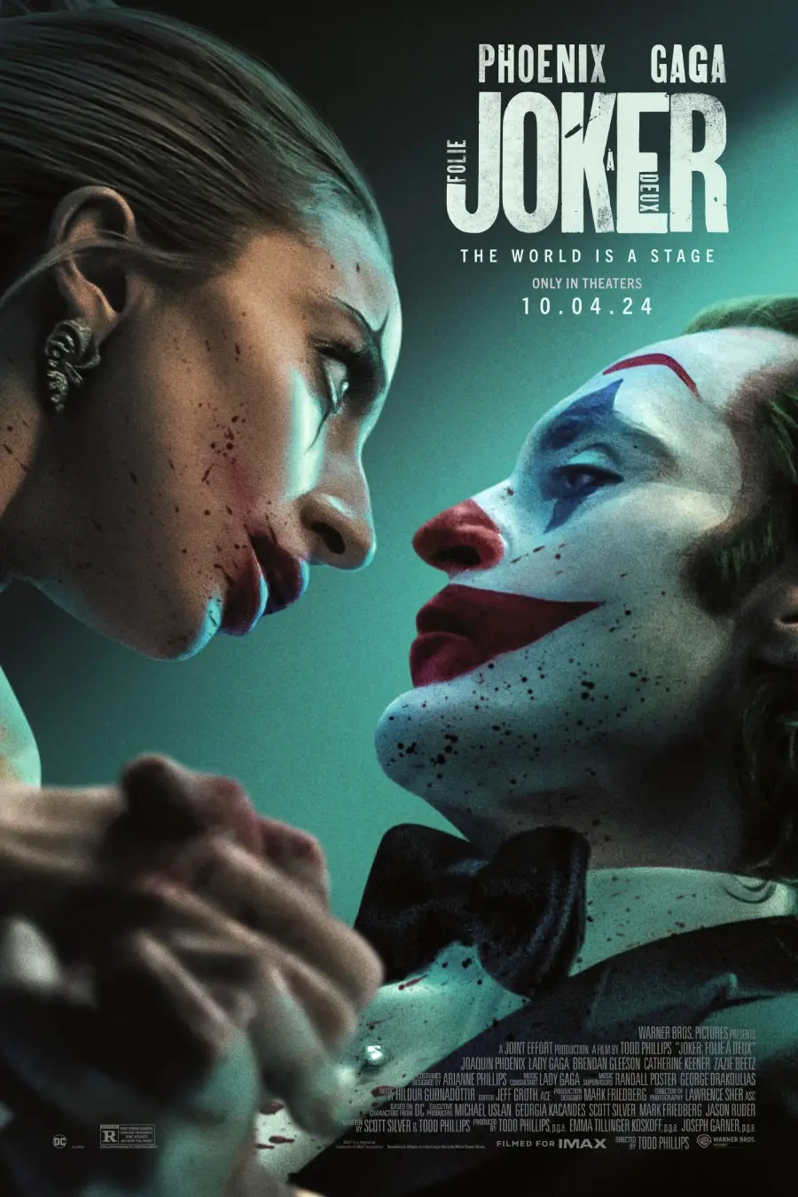 A woman with smeared makeup leans close to a man dressed as a clown with white face paint, red lips, and blue designs. The poster text reads "Joker: Folie à Deux," starring Phoenix and Gaga, releasing 10.04.24.