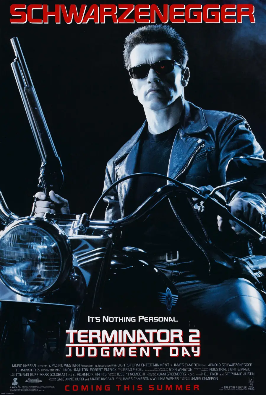 A man in sunglasses and a leather jacket sits on a motorcycle, holding a shotgun. The text reads “Terminator 2: Judgment Day” with “Schwarzenegger” at the top and “Coming This Summer” at the bottom.