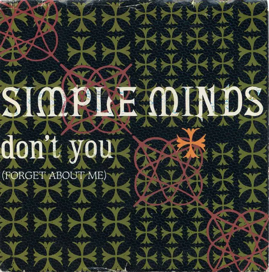 Album cover with a patterned background; text reads "SIMPLE MINDS don’t you (FORGET ABOUT ME)" in large and small fonts. Red and gold geometric shapes overlay the green and black design.