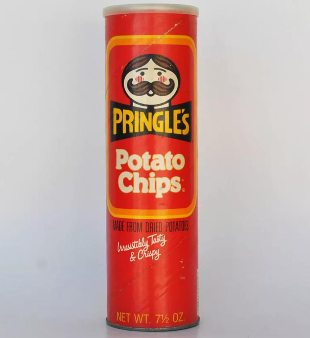 A vintage red can of Pringles Potato Chips with the classic Pringles mascot, labeled “Made from Dried Potatoes” and “Irresistibly Tasty & Crispy.” The can is 7.5 ounces.