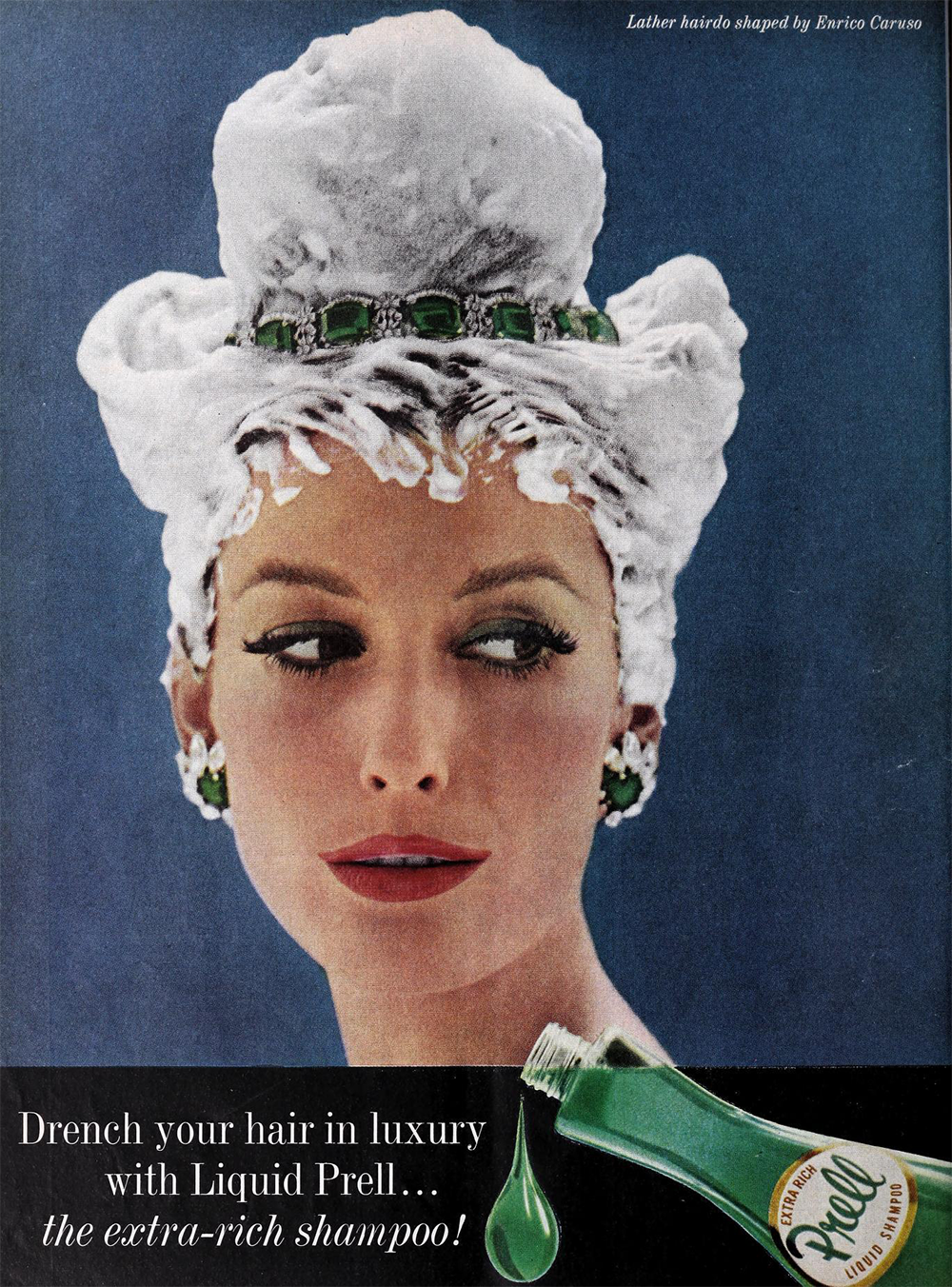 A woman with an elegant updo covered in shampoo lather, wearing green earrings and a matching necklace, gazes to the side. An open Prell shampoo bottle appears in the bottom corner with green shampoo dripping out.