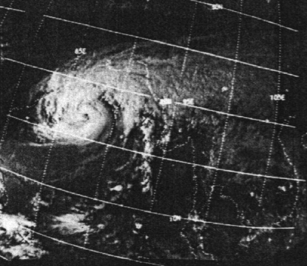 Black and white satellite image showing a swirling hurricane over the ocean, with grid lines and latitude/longitude markings overlaying the storm.