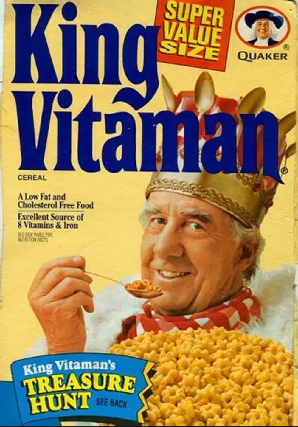 A cereal box featuring “King Vitaman” with a smiling man in a crown, a bowl of cereal, and “Super Value Size” and “Quaker” branding. Text highlights vitamins, iron, and a treasure hunt promotion.