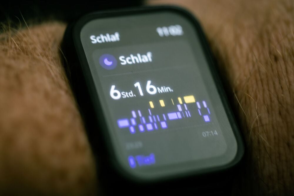 Smartwatch displaying sleep data in German, showing 6 hours and 16 minutes of sleep with a graph of sleep stages on the screen. The time “07:14” is visible at the bottom right.